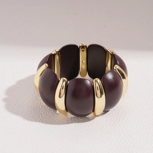 Detail of wide stretch bracelet with burgundy resin blocks and golden spacers