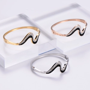 Polished wave-shaped stainless steel bangles set with black and white rhinestones