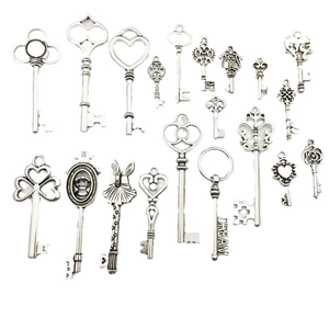 Collection of 19 assorted vintage silver metal skeleton keys with ornate patterns on white