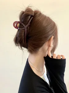 Deep burgundy large hair claw clip worn on a bun for a minimalist and elegant look