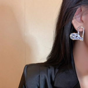Detailed close-up of heart wing earrings featuring premium cubic zirconia on model