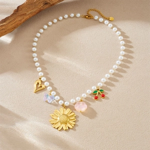 Chic pearl chain necklace with gold cherry heart and sunflower pendants on beige wood
