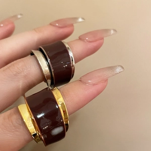 Detail view of gold and silver double-layered open rings with dark oil drip finish
