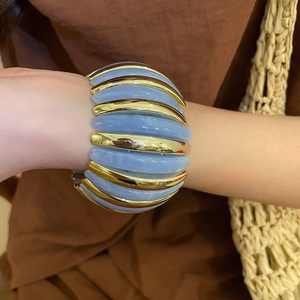 Elastic wide acrylic cuff bracelet with gold metal accents and blue marble resin texture