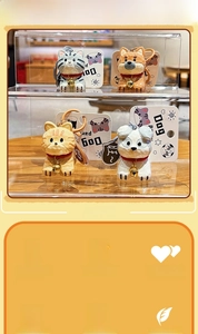 Detail of hand-carved resin pet keychains featuring cats and dogs with gold bells