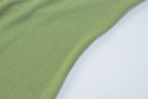 Macro shot of green glitter knit fabric texture with silver sparkles for elegant dress