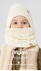 Detail of soft cream knitted beanie with pompom and thick neck warmer for kids