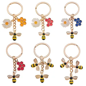 Cute bee keychains set with colorful enamel honeycomb and daisy pendants in gold finish