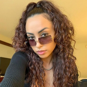 Close-up of rimless gradient purple sunglasses with gold metal bridge on female model