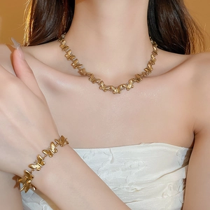 Minimalist matte gold butterfly necklace and bracelet jewelry set for women on model