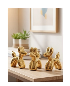 Dettaglio di sculture a forma di cane palloncino in ceramica dorata per la casa