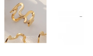 Macro view of minimalist U-shaped wavy gold ring with hollow geometric steel design