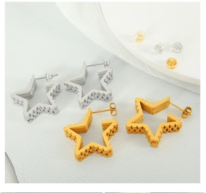Detail of star shaped earrings with wave texture in gold and silver finish