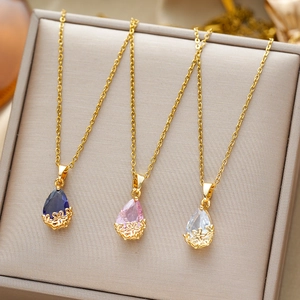 Golden teardrop necklaces with blue, pink and clear crystals on a jewelry box