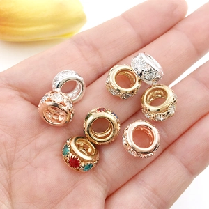 Rhine-set large hole spacer beads in gold silver and rose gold held in a hand