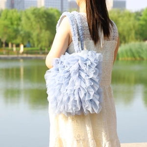 Detail of light blue mesh tote bag with tiered ruffles and soft tulle texture details