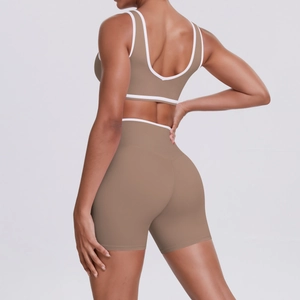 Detail of cross-waist yoga shorts and racerback bra with contrast white piping