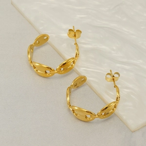 Polished gold pig nose C-shaped stainless steel earrings on a marble surface