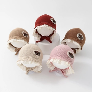 Detailed set of five knitted baby hats with lace trim and chin straps in various colors