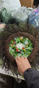 Detail of a handmade rustic wildflower wreath with colorful blossoms and green leaves