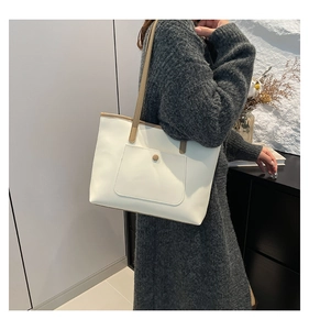 Detail of soft cream tote bag with khaki shoulder straps and front flap pocket button