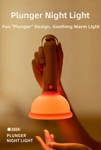Macro detail of plunger night light with wooden handle and warm orange LED glow
