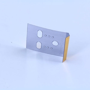 Macro view of silver metal trimmer blade with gold cutting edge and positioning holes