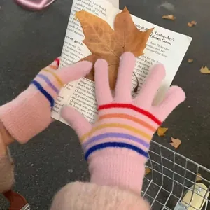 Pink knitted winter gloves with rainbow stripes and touch screen tips for warmth
