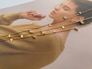 Detailed shot of three gold necklaces with geometric zircon pendants in various shapes