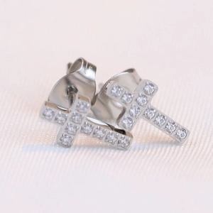 Macro shot of silver cross stud earrings with sparkling pavé cubic zirconia inlay