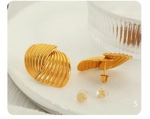Macro detail of gold striped textured earrings with metal and silicone backings