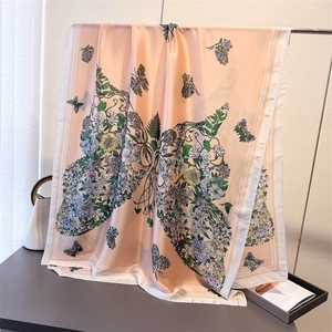 Dettaglio di sciarpa in seta con stampa farfalla floreale in tonalità rosa-arancio