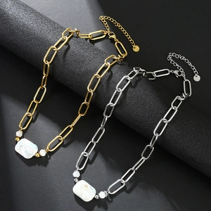 Collane in oro 18 carati e argento con perle barocche e catena a graffetta su base nera