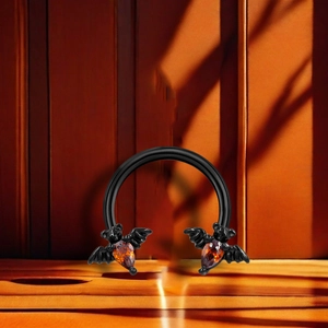 Black horseshoe ring featuring detailed bats and vibrant orange amber gemstones