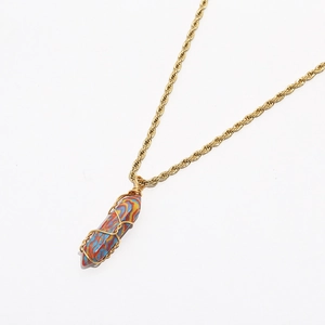 Detailed view of bohemian turquoise crystal pendant with golden artistic wire wrapping