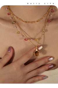 Gros plan détaillé d'un collier triple rang plaqué or avec pendentif en pierre oeil de tigre
