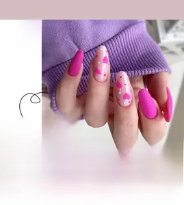 Detail of almond-shaped Valentine's Day press-on nails with matte rose and heart patterns