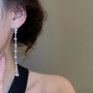 Close-up of elegant long silver tassel earrings with zircon water drop stones on model