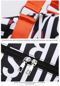 Detail of high-capacity travel bag featuring reinforced orange handles and dual metal zippers