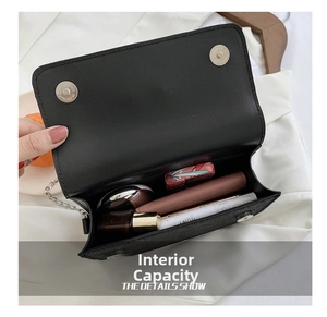 Internal capacity of black chain shoulder bag showing makeup and card holder details
