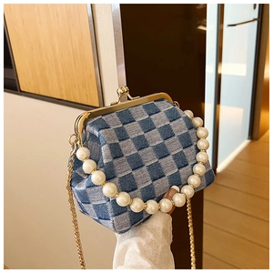Detail of blue and white checkered purse with pearl handle and golden clasp closure