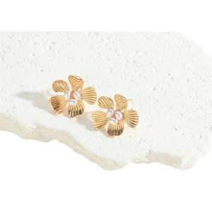 Elegant gold flower earrings with three center pearls on a white marble background