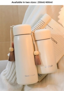 Detailed view of mini cream thermal flasks in 250ml and 400ml sizes with elegant tassels