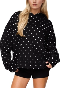 Close-up of black hoodie featuring white polka dot patterns and a front kangaroo pocket