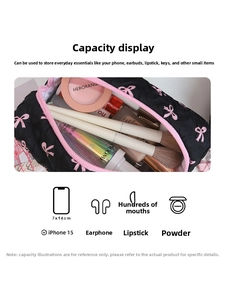 Inside view of black quilted cosmetic bag with pink bows showing large capacity storage