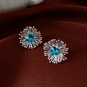 Silver stud earrings with blue heart zircon in radiant sunburst flower design