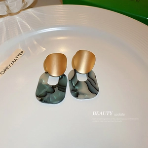 Geometric acrylic drop earrings with marble pattern and matte gold finish metal shield