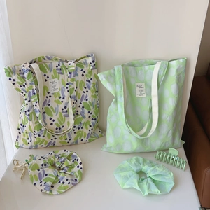 Detail of printed cotton tote bags with matching scrunchies and a matte hair claw clip
