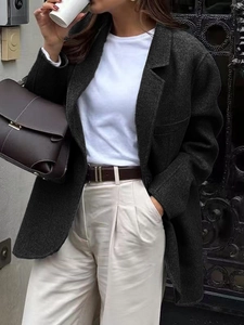 High-quality street style photo of dark gray wool blazer with brown leather handbag