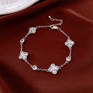 Elegant silver four-leaf clover bracelet with sparkling cubic zirconia on red silk